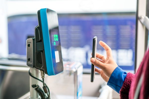 Passenger using smart phone to pay in the bus